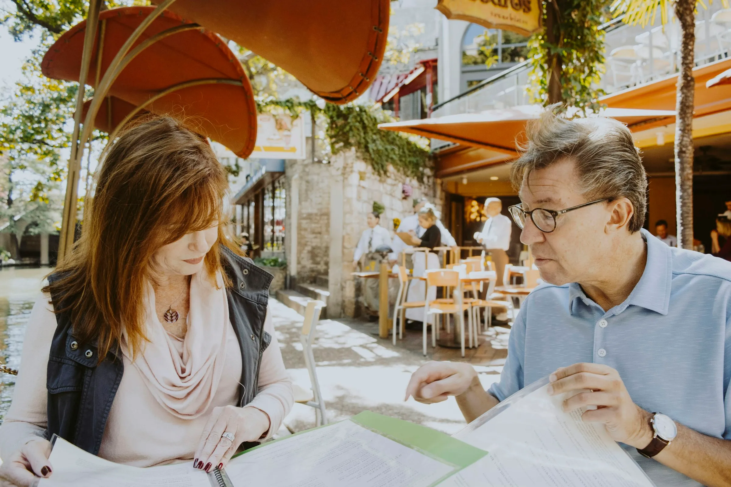A couple reading through investment papers at a café table