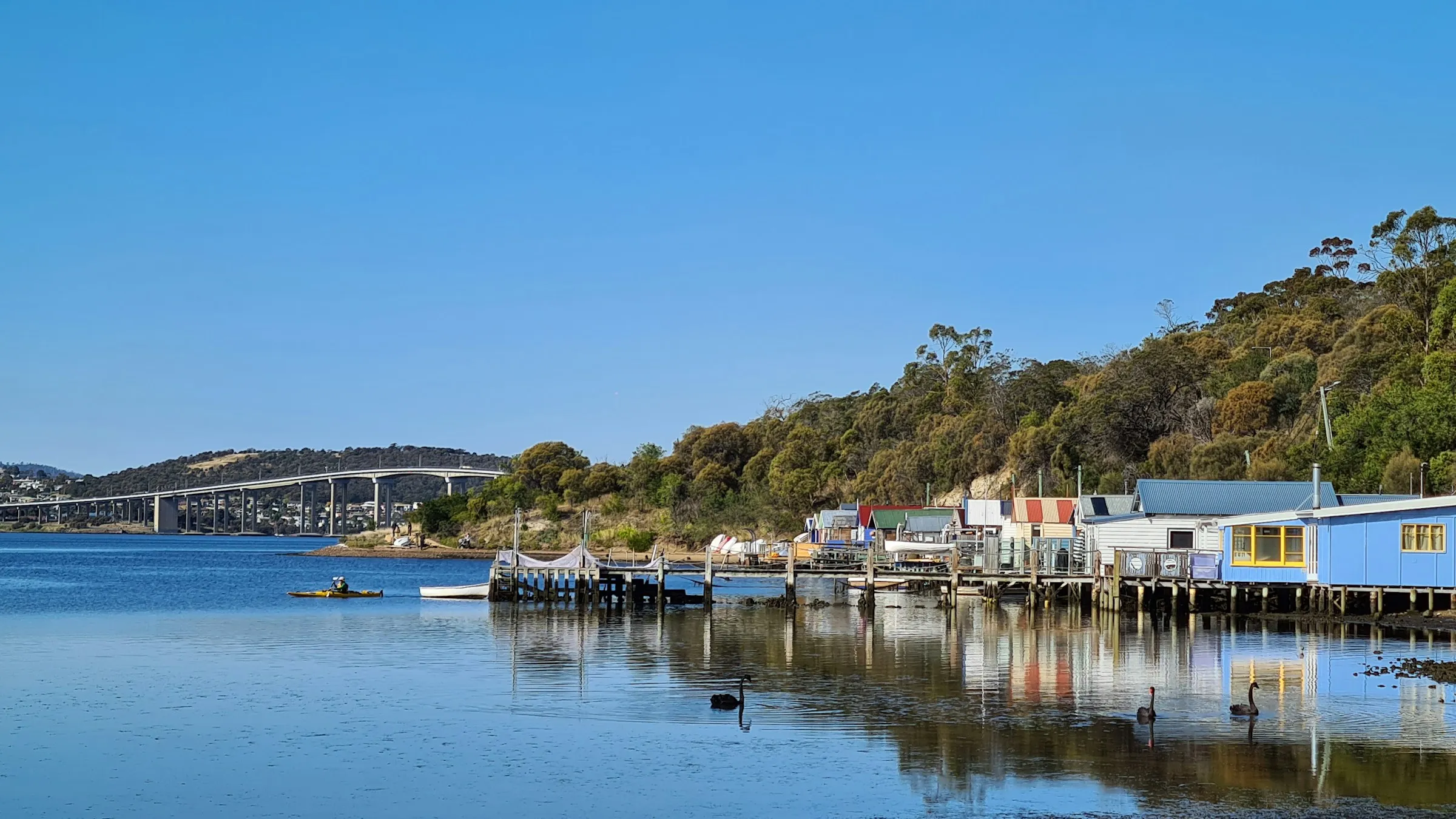 Boathouses on the Derwent River in Hobart under a blue sky