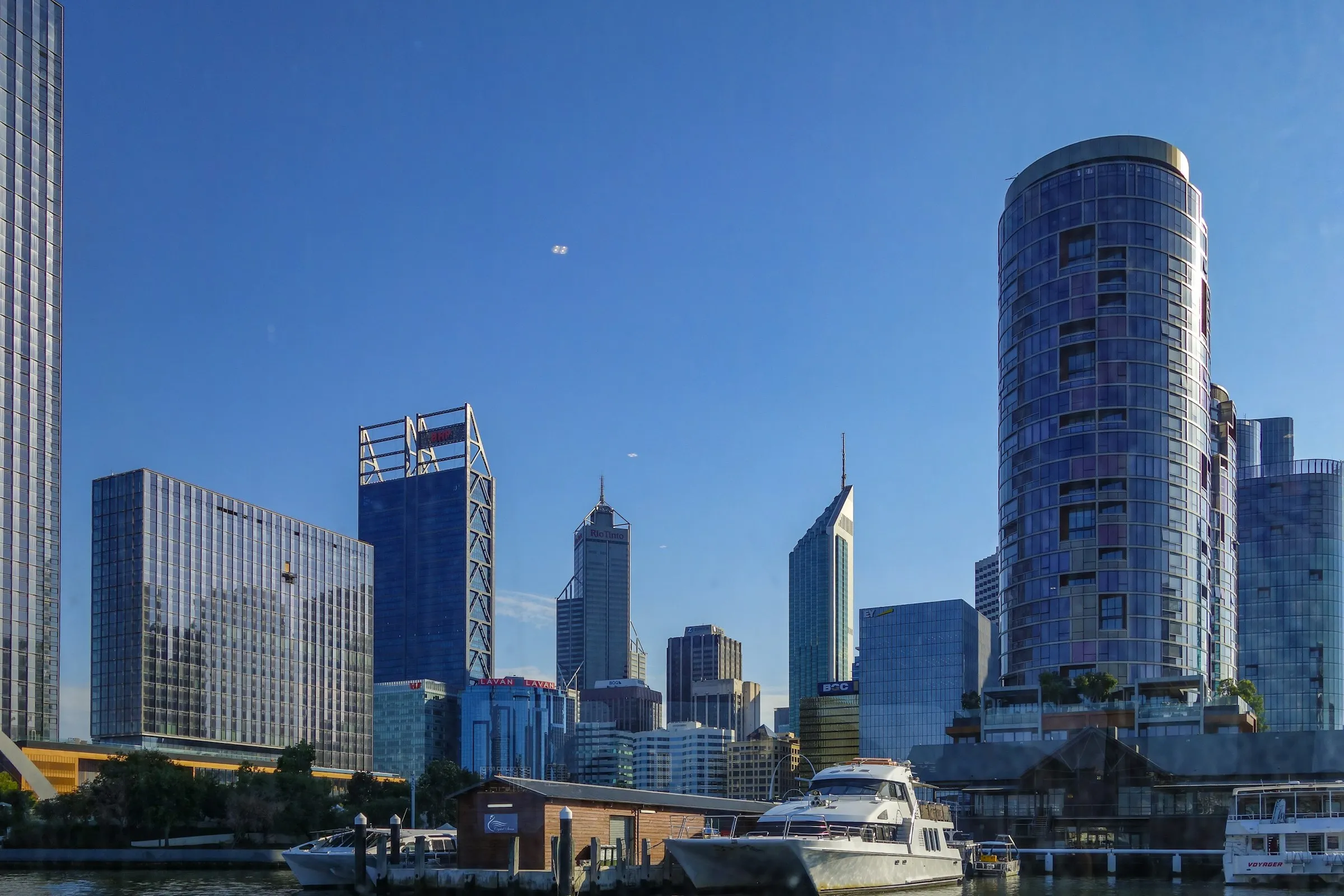 Perth city towers and boats on the water under a blue sky