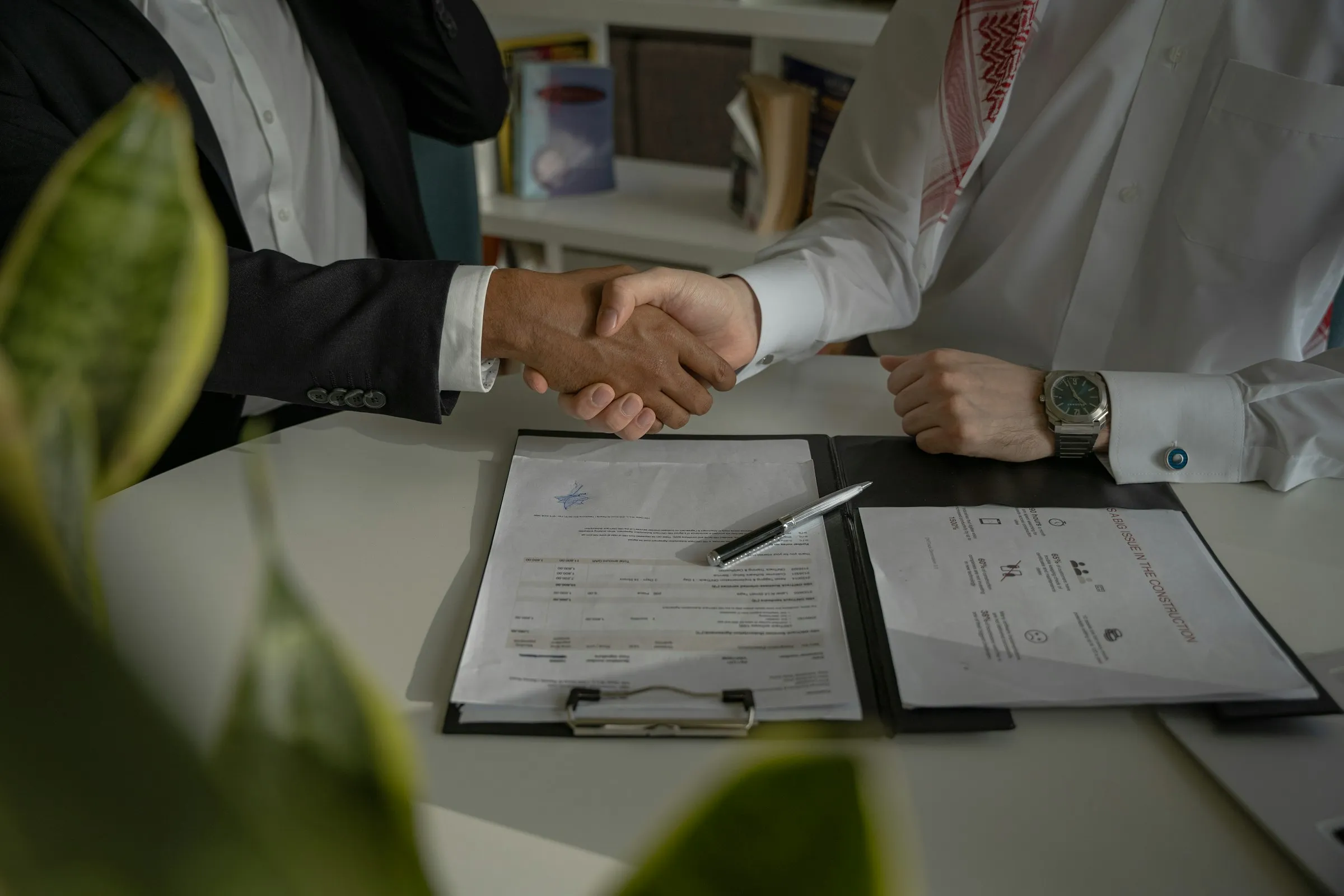 Investor signing mortgage and loan documents at a desk